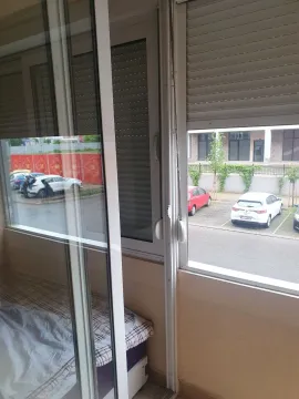 View from a glazed balcony overlooking the parking lot and street. - image 17