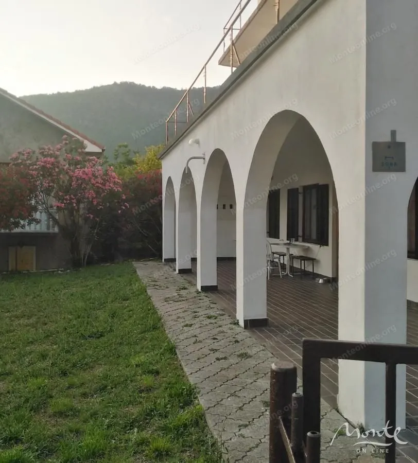 View of the covered terrace with columns and the courtyard in front of the house.