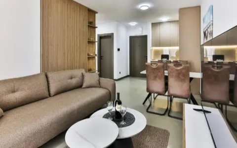 Living room with a sofa, coffee table, and adjacent dining area. - image 3