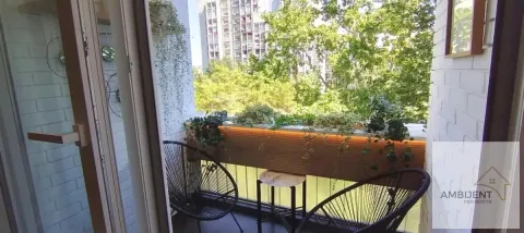 Furnished balcony with chairs, a small table, and greenery. - image 18