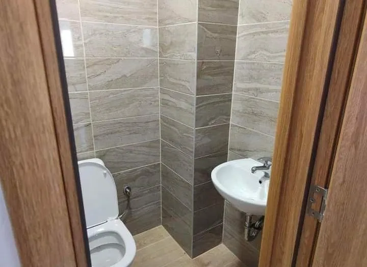 Small bathroom with tile finishes, a toilet, and a sink.