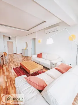 Spacious living room with white sofas, wooden flooring, and modern lighting. - image 18