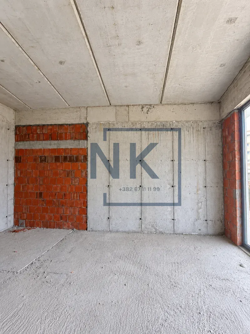 Unfinished room in rough construction with concrete and brick walls.