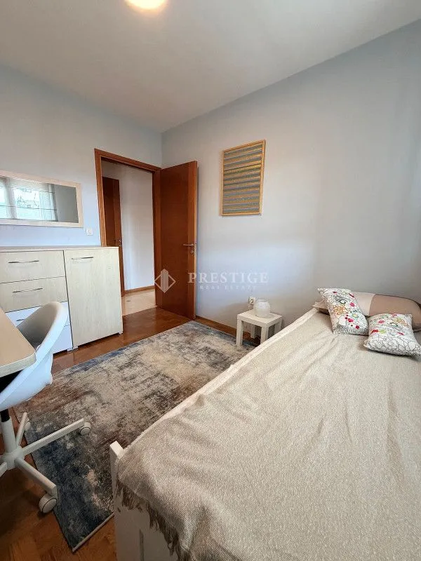 Furnished bedroom with a bed, desk, and wardrobe.