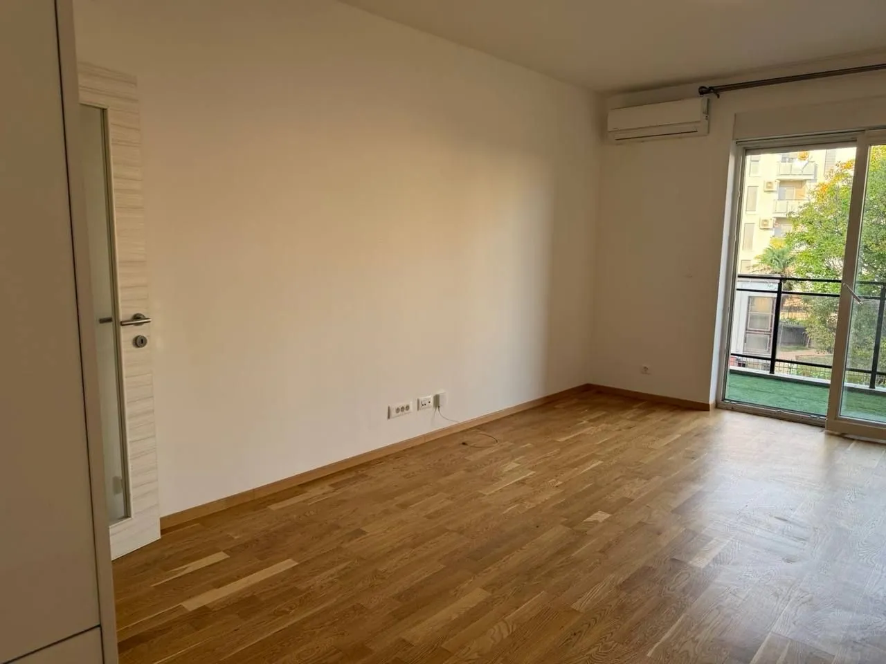 Empty room with hardwood floors and access to the terrace.