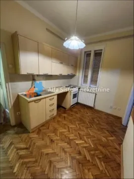 Small kitchen with light wooden cabinets and parquet flooring. - image 9