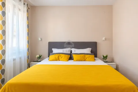 Cozy bedroom with a double bed, yellow details, and a window with curtains. - image 26