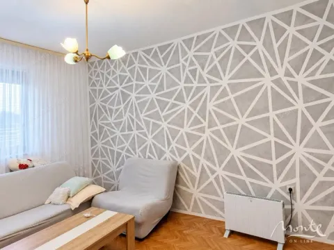 Dnevna soba sa garniturom i zidom ukrašenim geometrijskim šarama. - image 5