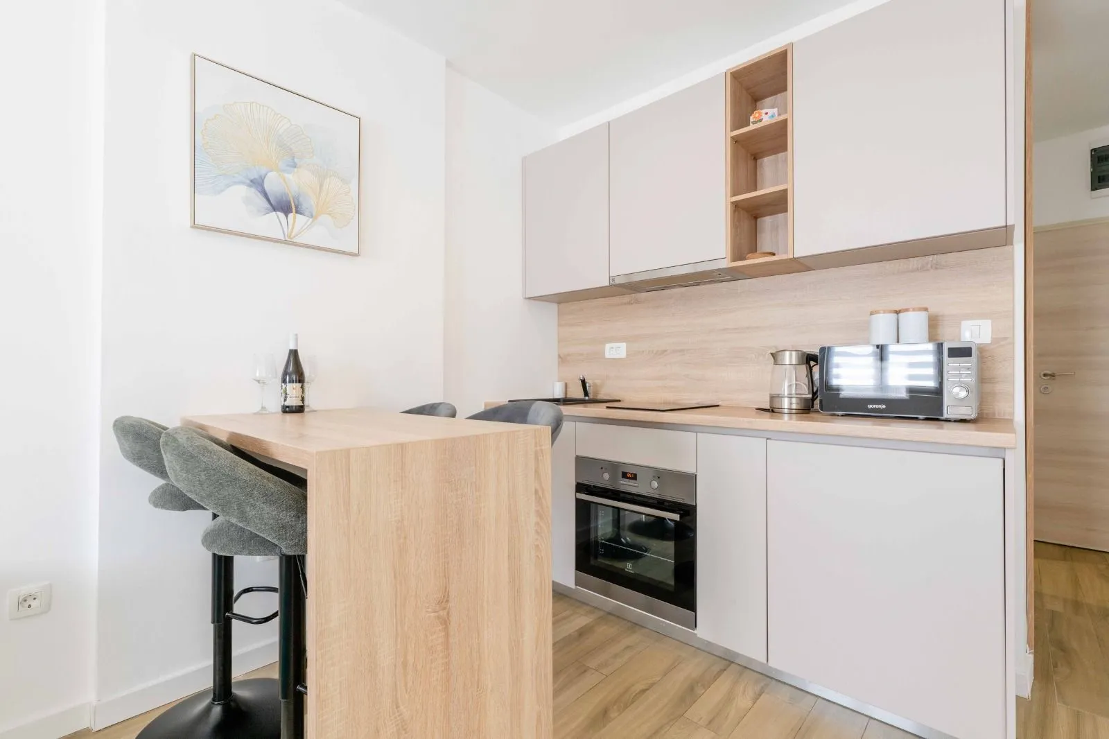 Modern kitchen with a bar counter and wooden elements.