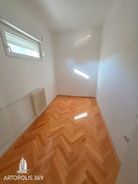 Prazna svetla soba sa parketom i radijatorom. - image 11
