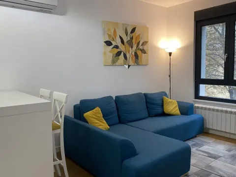 Living room with a blue sectional sofa and an artwork on the wall. - image 12