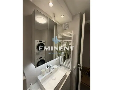 Modernly equipped bathroom with a washbasin, mirror and washing machine. - image 17