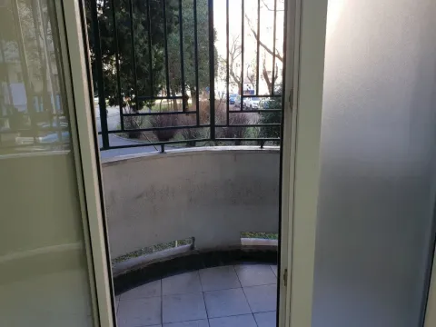 View of a small semi-circular balcony with a metal railing through an open balcony door. - image 9