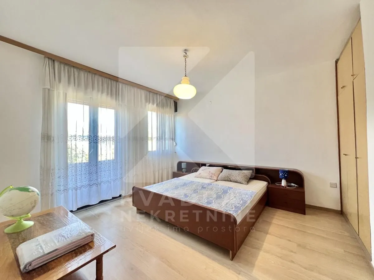 Bedroom with a double bed, wardrobe, and balcony access.