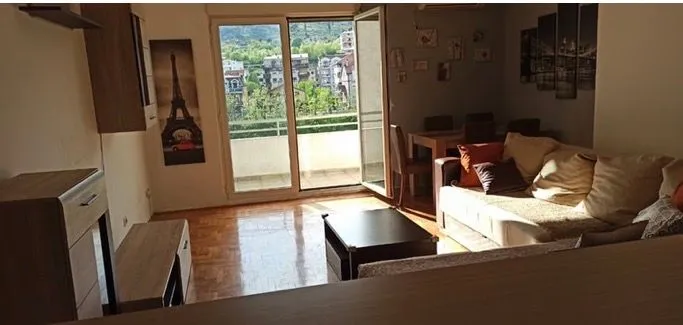 Namještena dnevna soba sa garniturom i izlazom na terasu.
