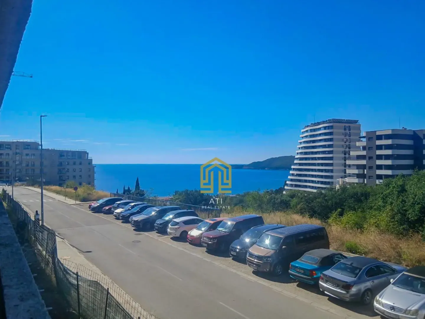 Pogled na more i okolne zgrade sa terase nekretnine.