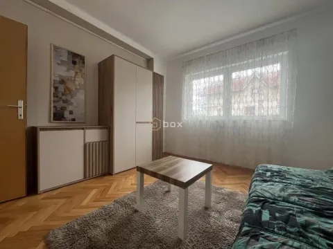 Smaller living room with a sofa, coffee table, wardrobe, and wooden floor. - image 10