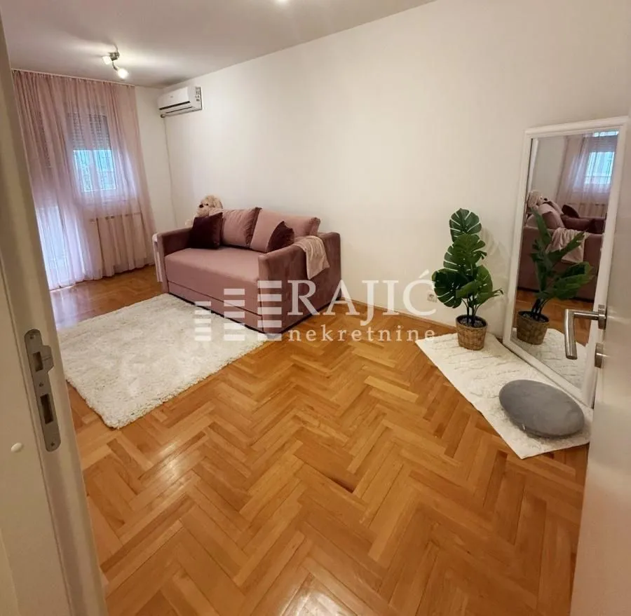 Living room with a sofa and parquet flooring.