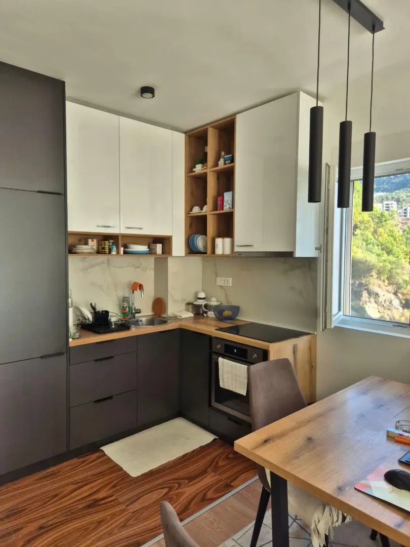 Modern kitchen with dark and white cabinetry and a dining table.