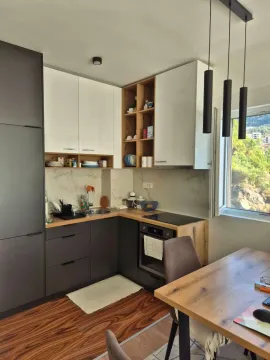 Modern kitchen with dark and white cabinetry and a dining table. - image 7