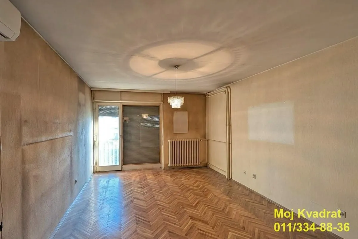 Prazna soba sa parketom i izlazom na terasu.