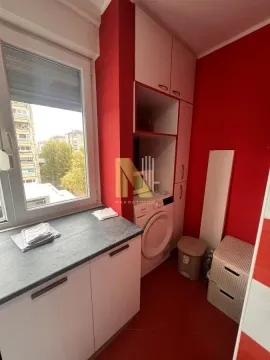 Manja kuhinja sa belim elementima i mašinom za veš pored prozora. - image 8