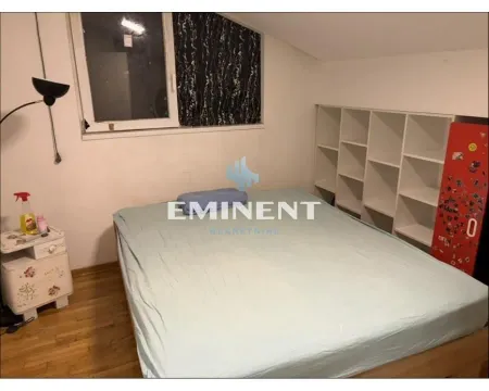 Small bedroom with a bed, white shelving unit, and a window. - image 7