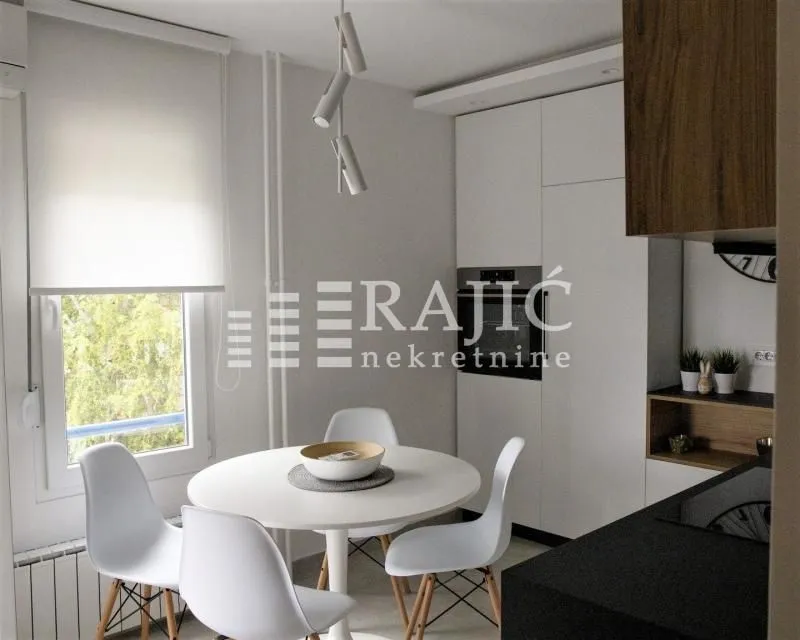 Modern kitchen with a dining table and white chairs.