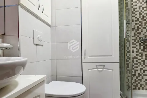 Smaller bathroom with white cabinets, a washbasin, and a shower cabin. - image 7