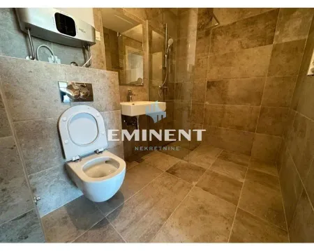 Tiled bathroom with a walk-in shower and a wall-mounted toilet. - image 17