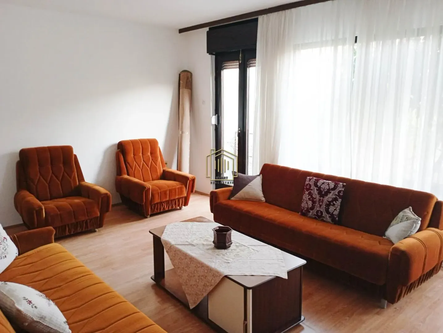 Living room with a brown sofa set and armchairs.