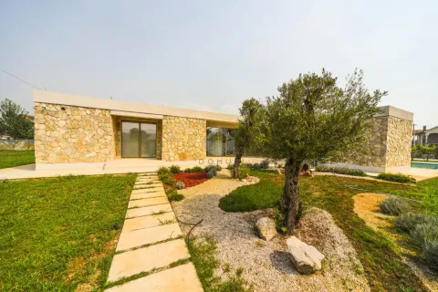 Exterior of the house with a landscaped yard, lawn, and an olive tree. - image 4