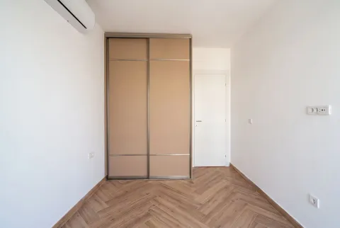 Svijetla prazna soba sa ugradnim kliznim plakarom i parketom u obliku riblje kosti. - image 5