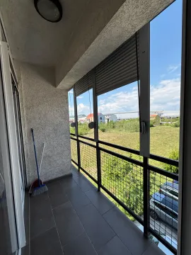 Enclosed balcony with a view of the surroundings and parked cars. - image 6