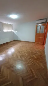 Prazna soba sa parketom na podu i drvenim vratima. - image 2