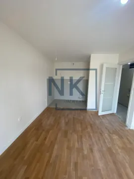 Prazna prostorija sa drvenim podom i pripremljenim priključcima za kuhinju. - image 5