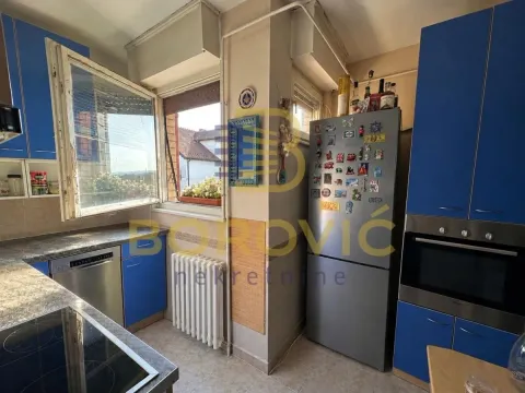 Kuhinja sa plavim elementima, prozorom i ugrađenim aparatima. - image 4