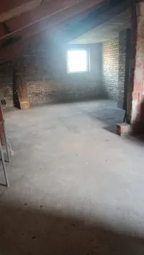 Potkrovlje u sivoj fazi izgradnje sa prozorom i kosim drvenim krovom. - image 12