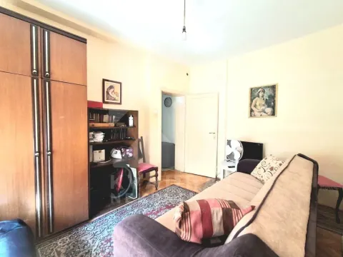 Dnevna soba sa kaučem, ormarom i policama za knjige. - image 6