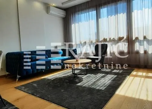 Modern living room with a sofa and large windows.