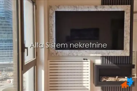 Dnevna soba sa velikim televizorom i kaminom na zidu. - image 13