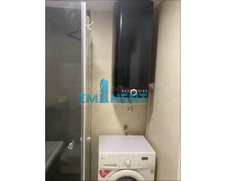 Bathroom with a shower cabin, water heater, and washing machine. - image 11