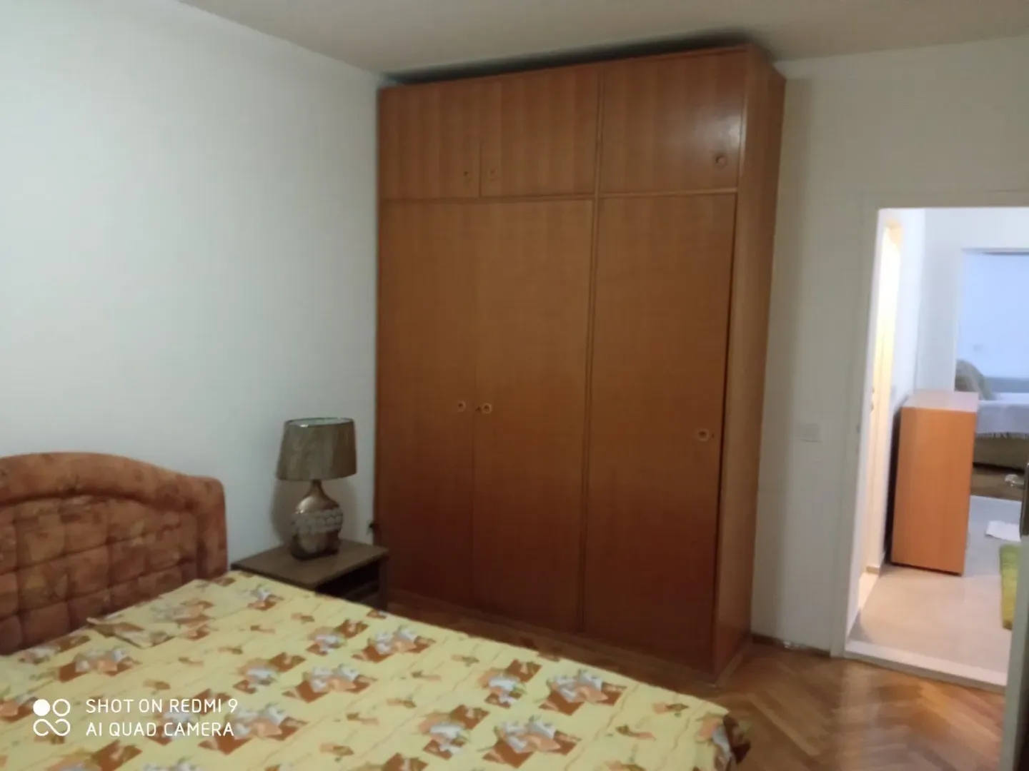 A bedroom with a large wooden wardrobe.