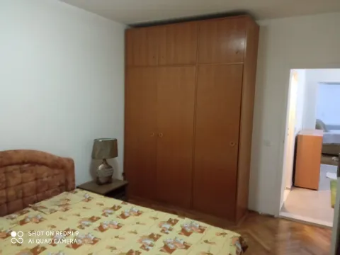 A bedroom with a large wooden wardrobe. - image 9