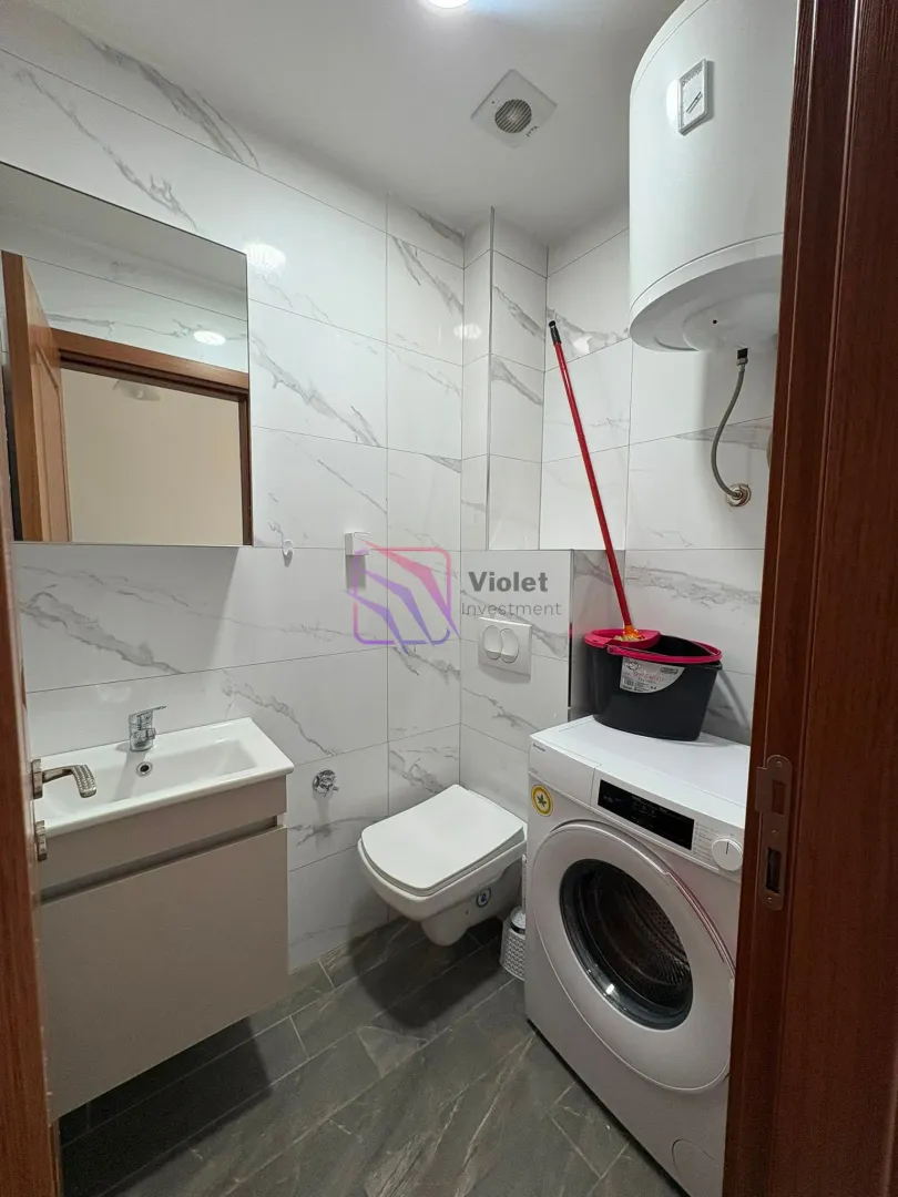 Bathroom equipped with sanitary ware, a sink, a washing machine, and a water heater.