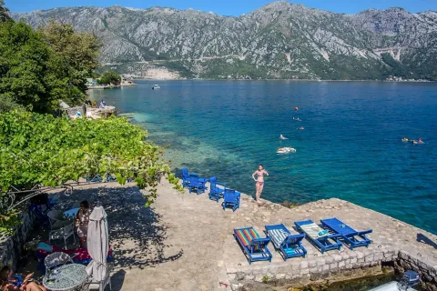Betonska plaža i terasa sa ležaljkama pored mora i pogledom na planine. - image 4