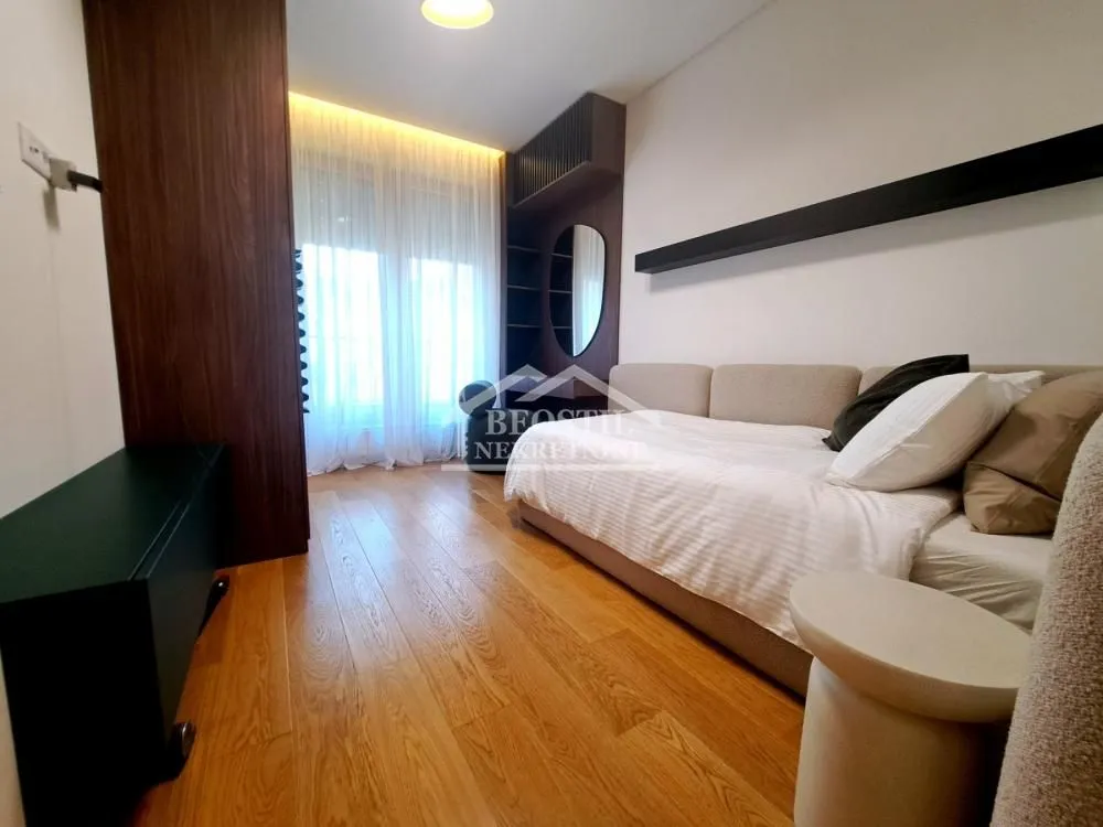 Modern bedroom with a bed, wooden flooring, and a built-in wardrobe.