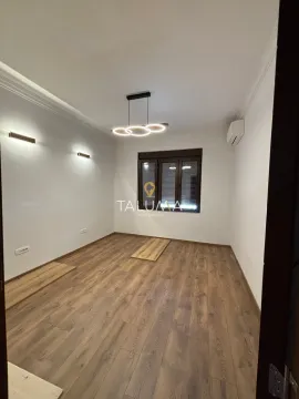 Empty room with wooden flooring, white walls, and modern ceiling lighting. - image 2