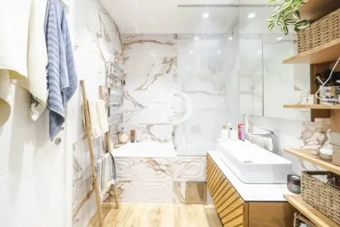 Moderno kupatilo sa belim sanitarijama i mermernim pločicama. - image 5