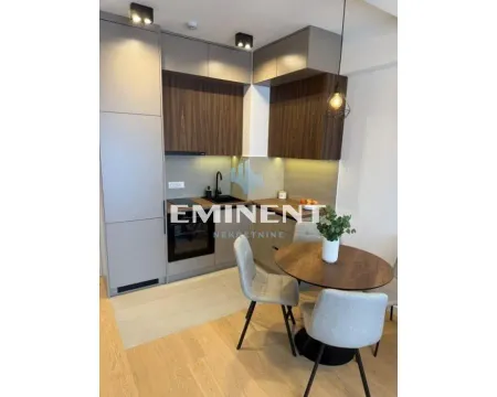 Modern kitchen with built-in units and a dining table with chairs. - image 2